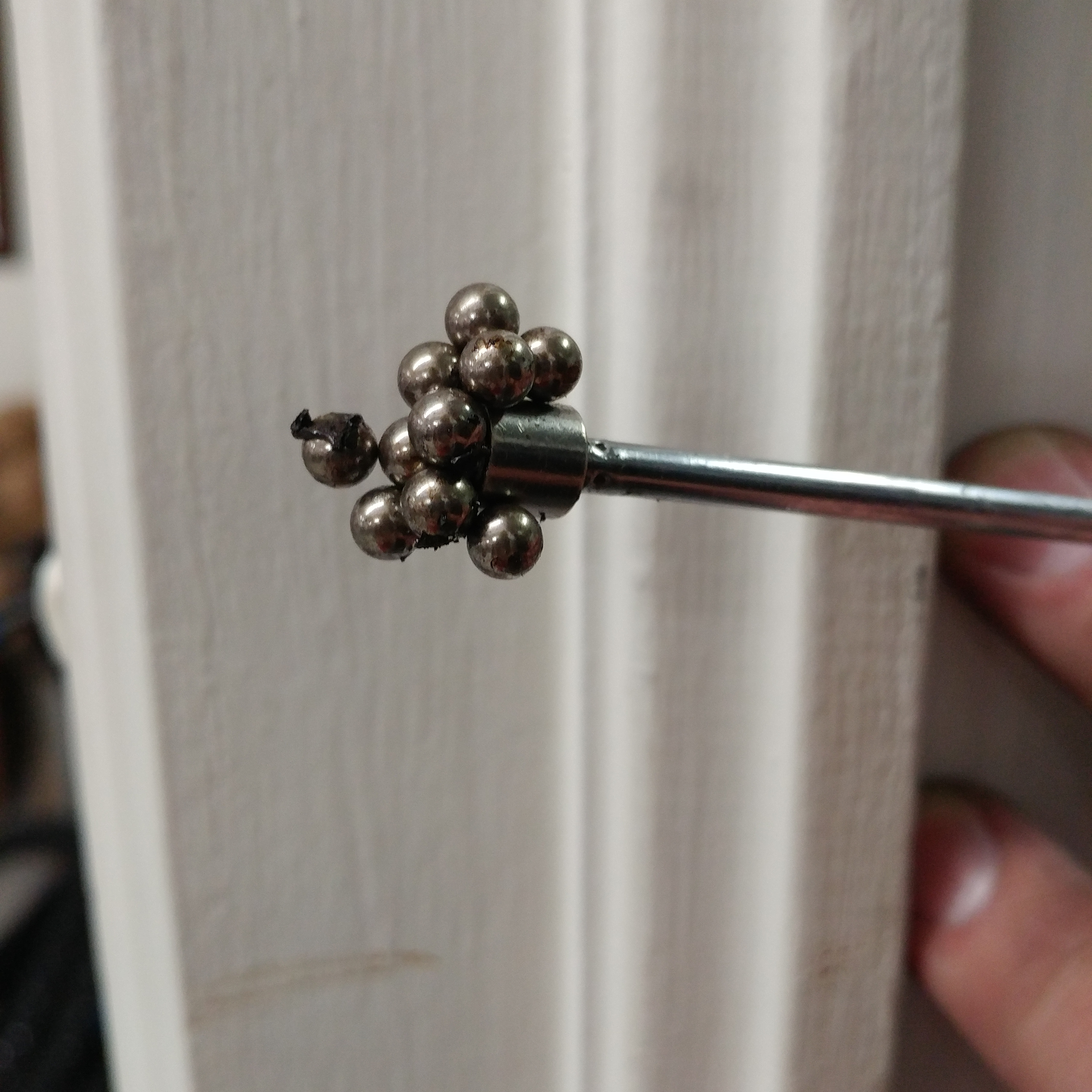 A close up of some grease-less bearings held magnetically to the gather tool in a clump.