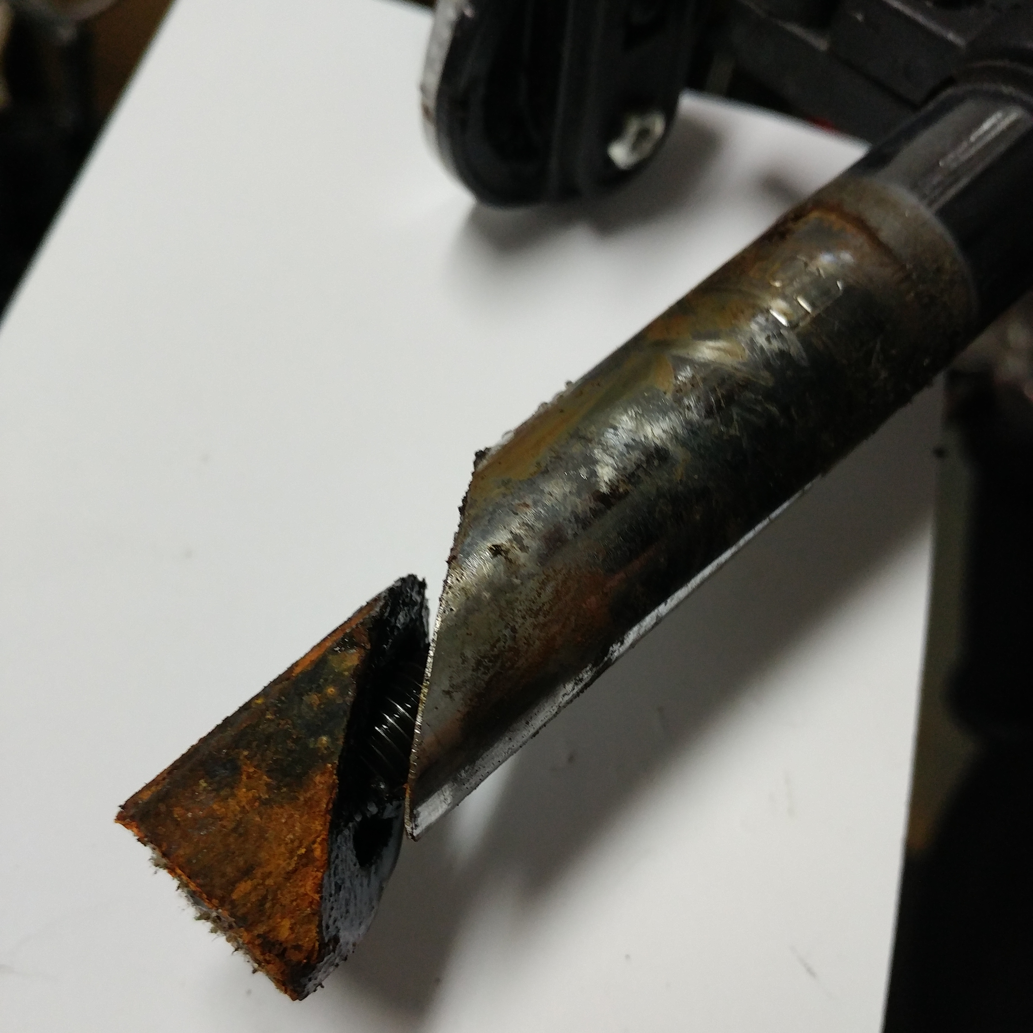 Close up of the bottom of a quill stem which is covered in a light layer of rust.