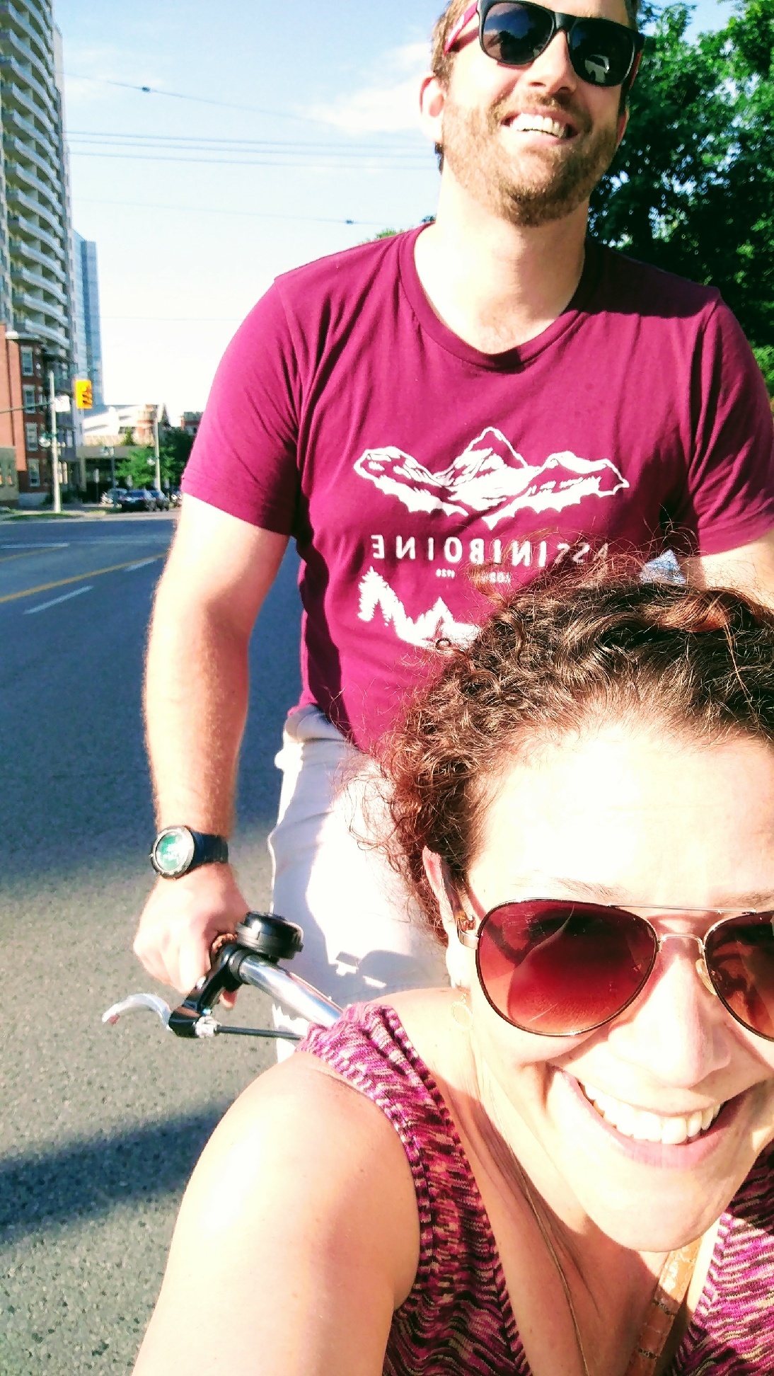 A sunny summer shot of Ben riding with Caroline in the box of a box bike.