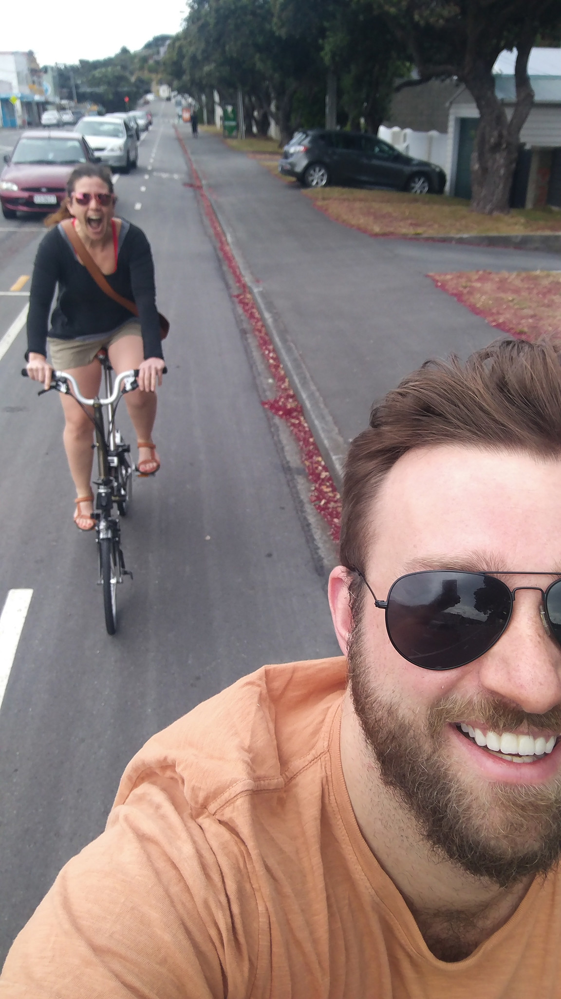 Ben smiles as he takes a selfie over his shoulder at a joyous Caroline on her Brompton bike. 