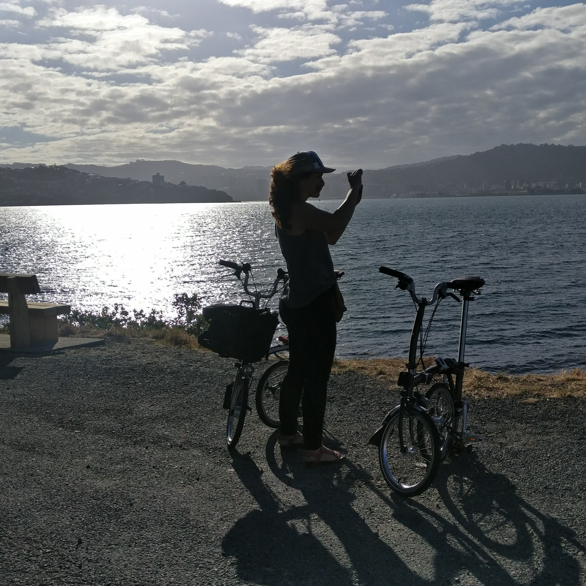 Caroline takes a photo of something out of frame as the light fades on her and her Brompton.