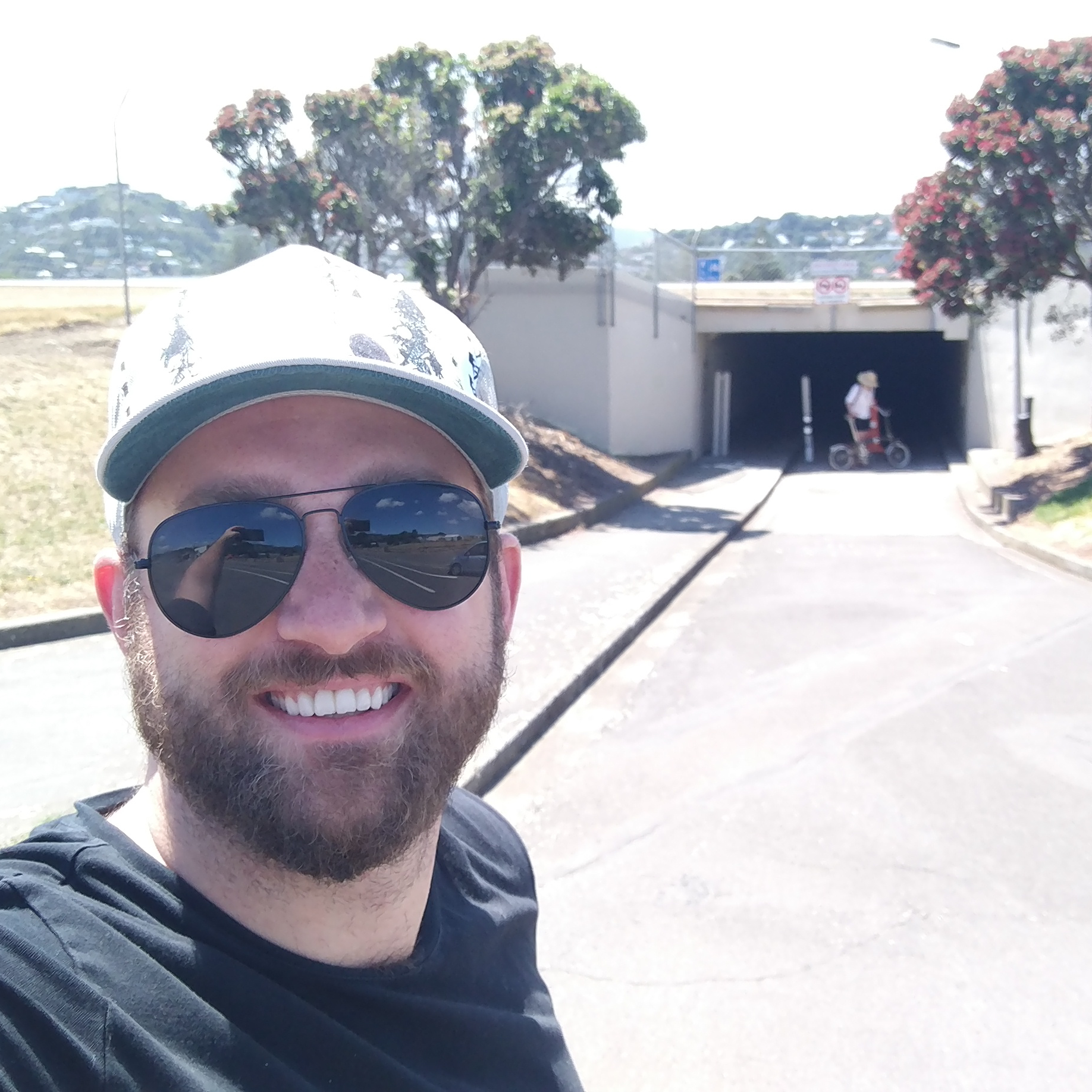 Ben takes a smiling selfie with a cycle/pedestrian tunnel behind him.