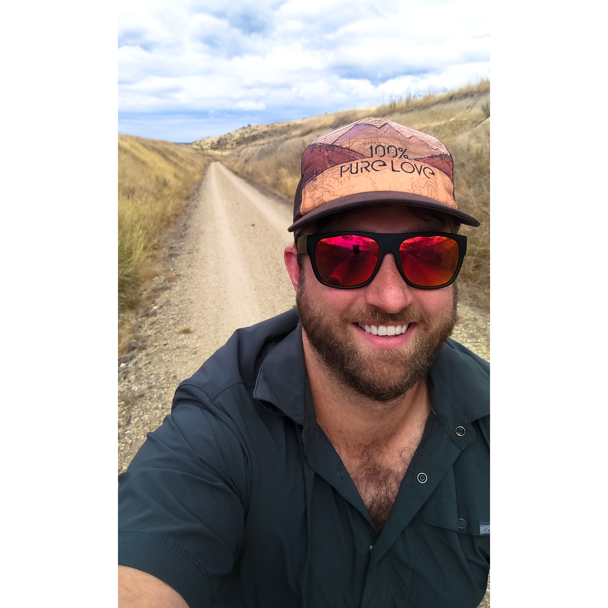 Ben takes a smiling selfie, the desert trail behind him.