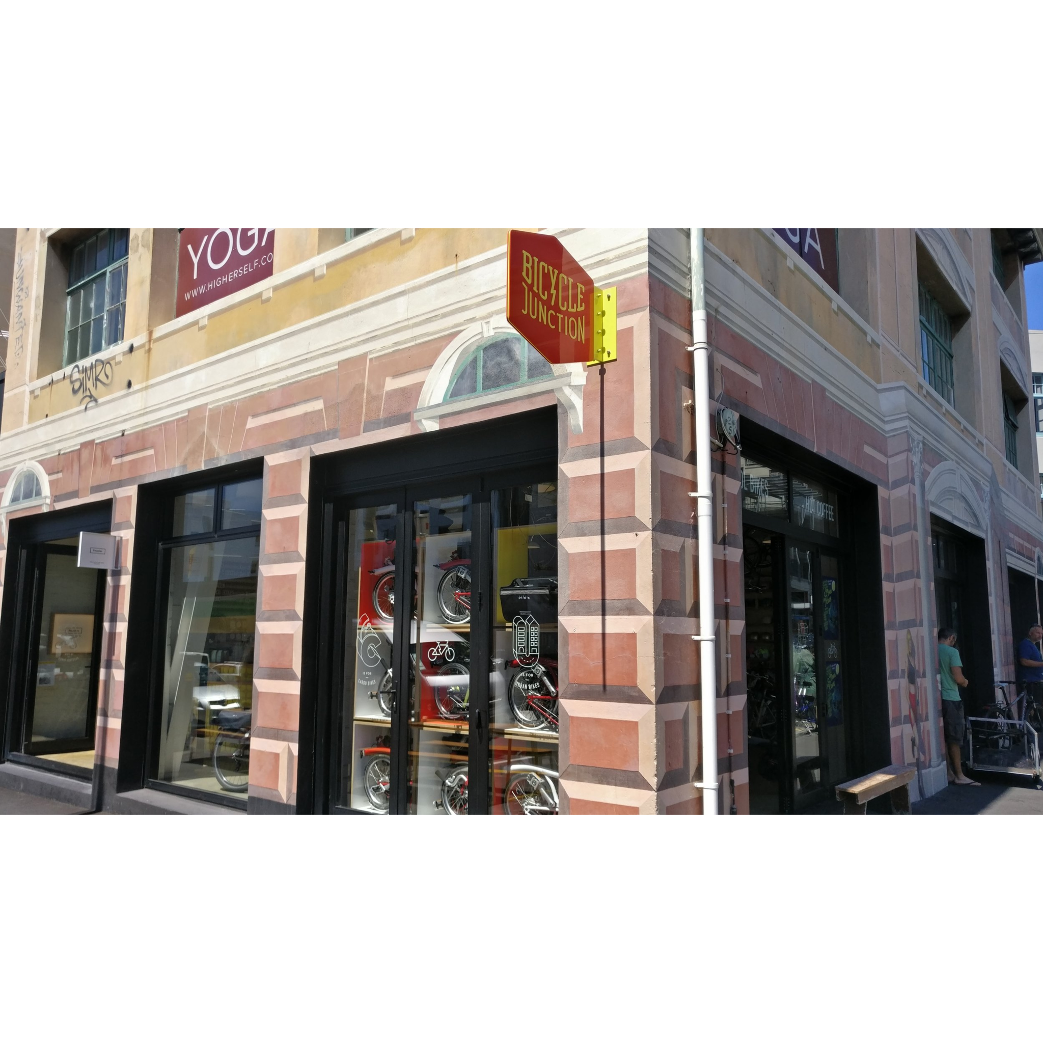 The exterior of Bicycle Junction, Bromptons folded in wooden cubes in the window.