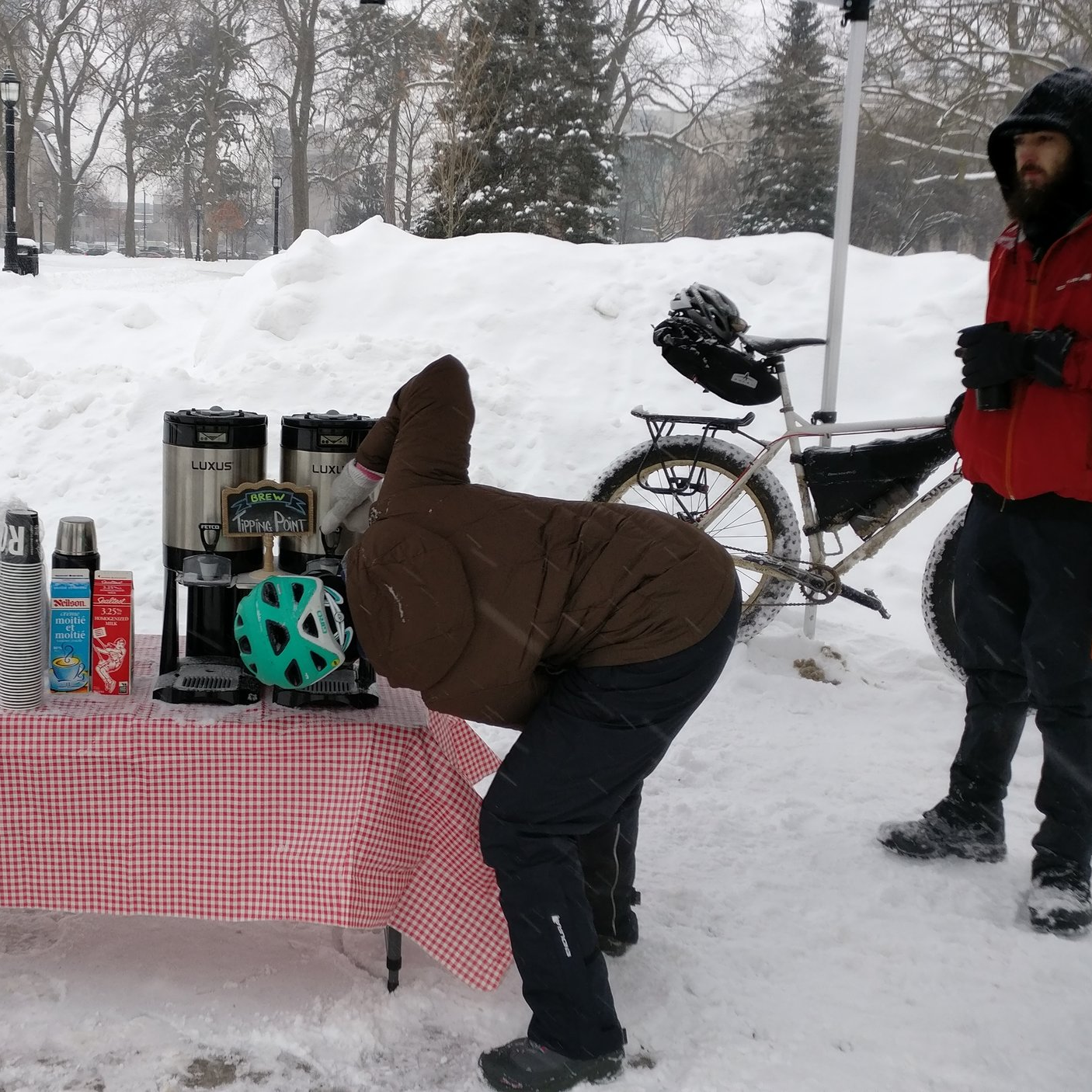 A winter cyclist checks to see if there's any coffee left in the carafe.