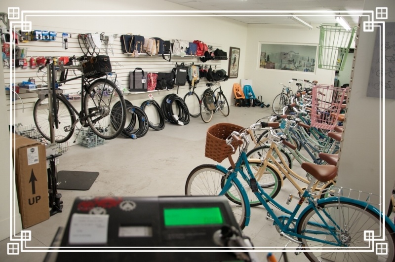 A row of colorful step through bikes on the right, a bike up in the stand on the left.