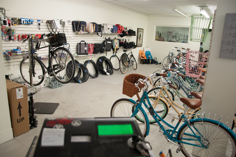 A retail wall of locks and saddles and bells, some colourful step through bikes off to the right.