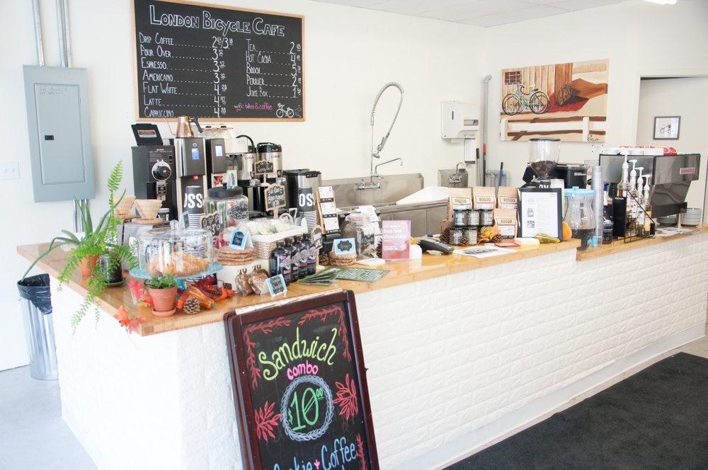 The coffee bar, bright and full of goodies with the menu sign beyond.