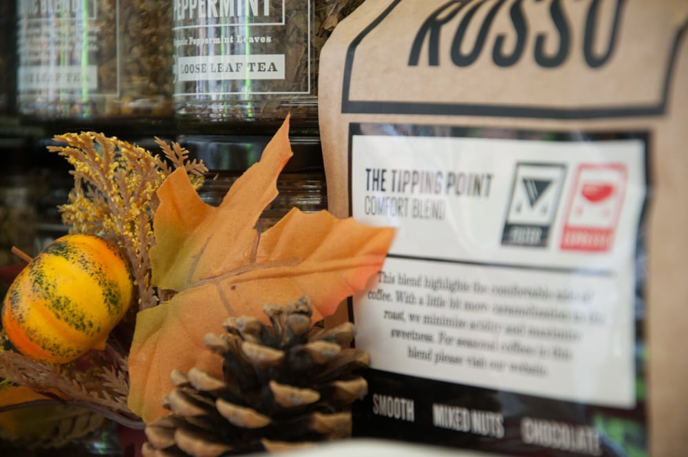 A close up of some Rosso coffee bags and a pinecone.
