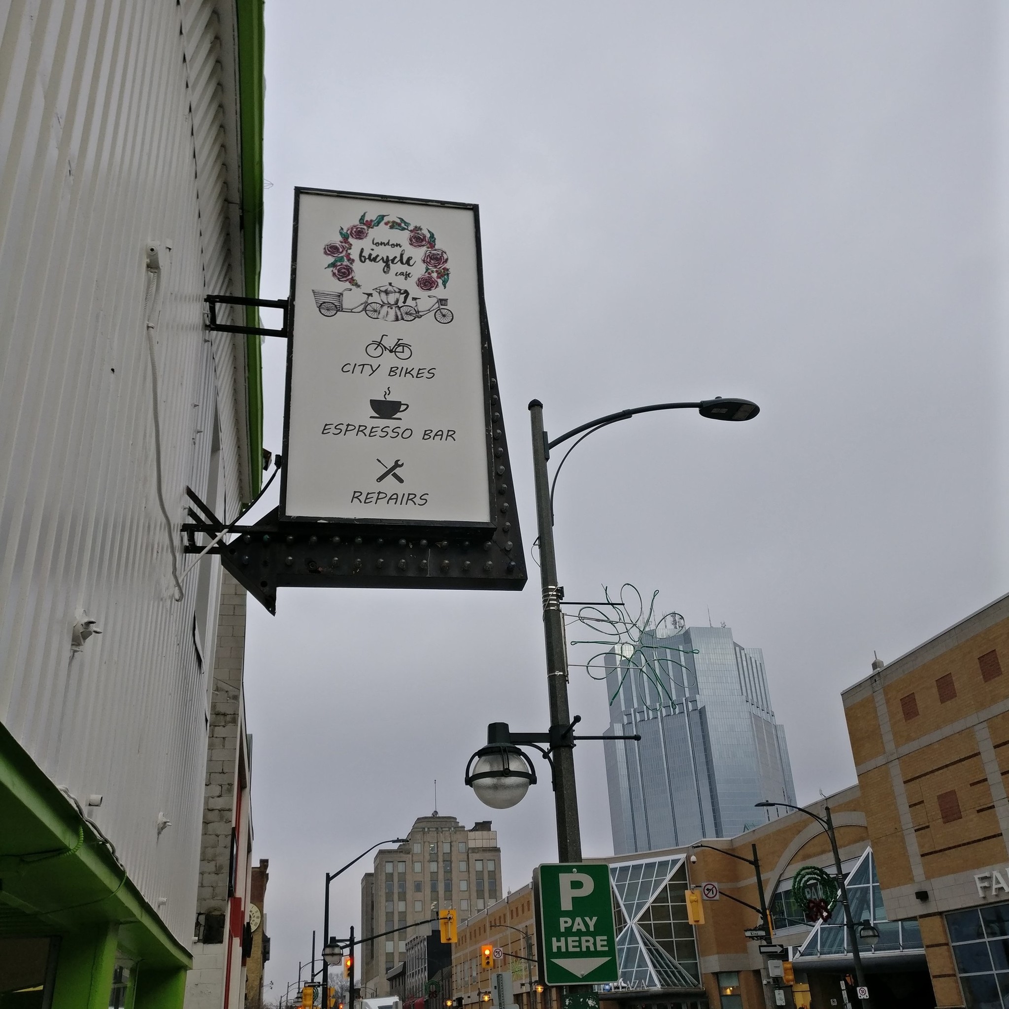 A look up at the store sign with the downtown towers in the background.