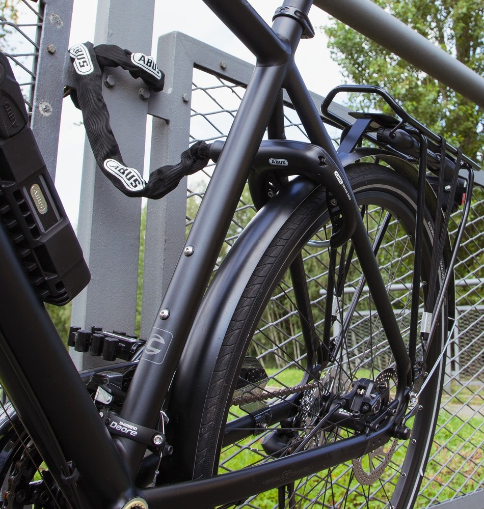 A cafe lock on a bike with the chain adaptor attached to a nearby pole.