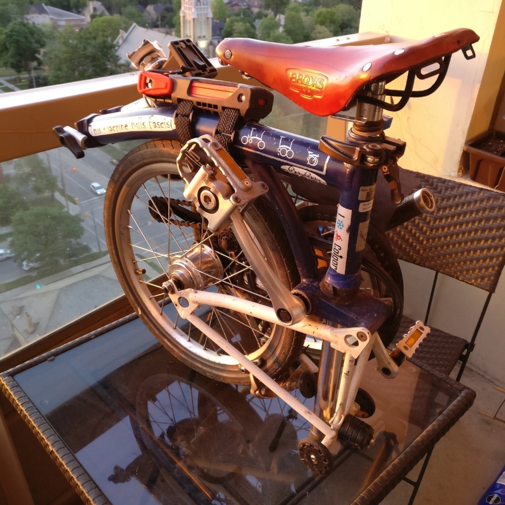 A folded Brompton in sunset light on an apartment balcony