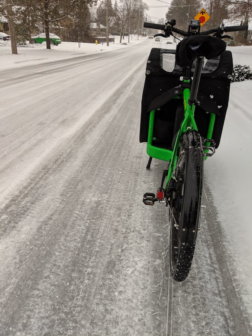 Another view of the green Bullitt long john bike on a snowy path