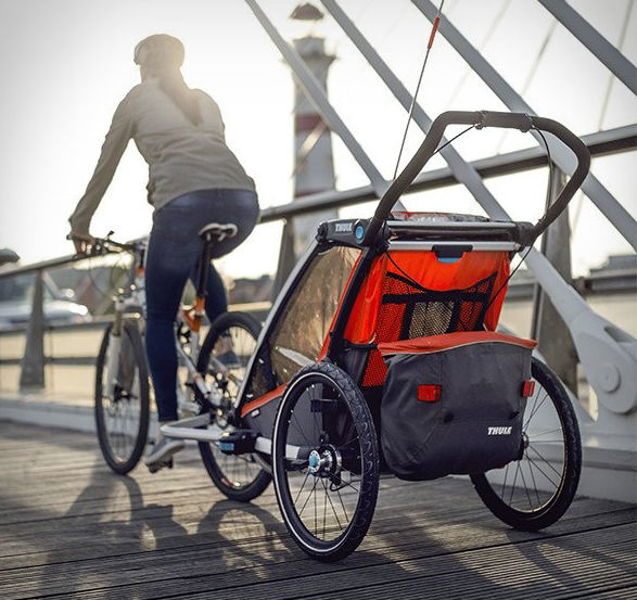 Thule chariot being pulled by someone on their bicycle.