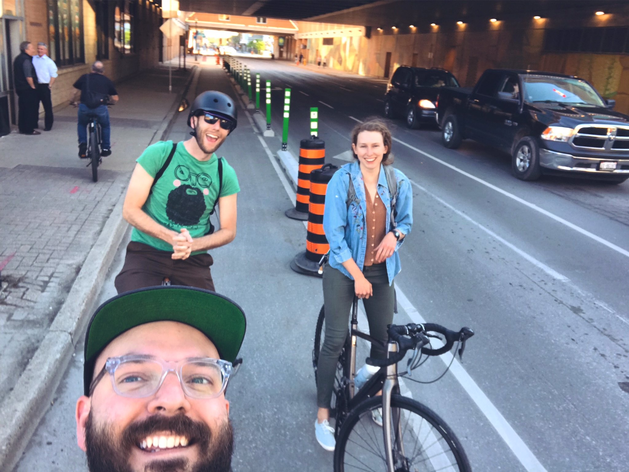 Three cyclists in the King St bike lane take a smiling selfie.