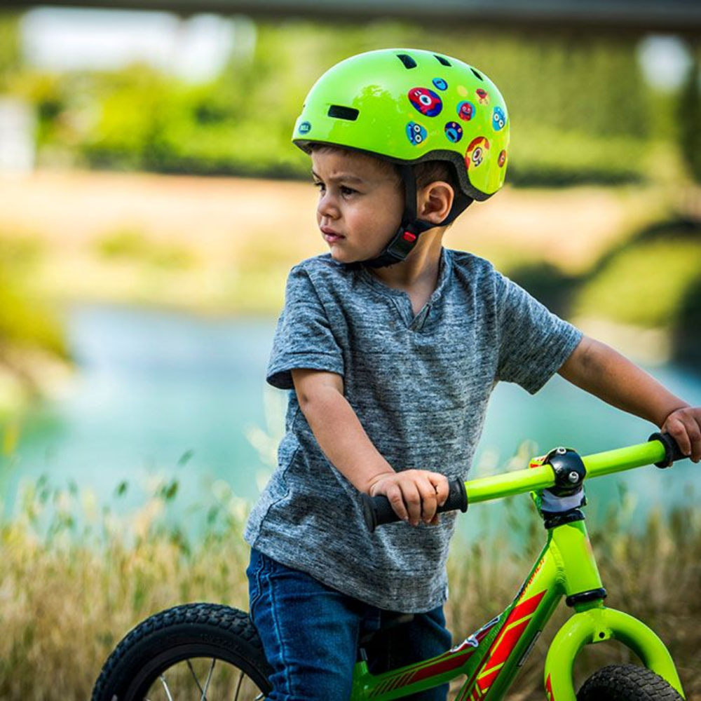 Kid with a green helmet and a bicycle