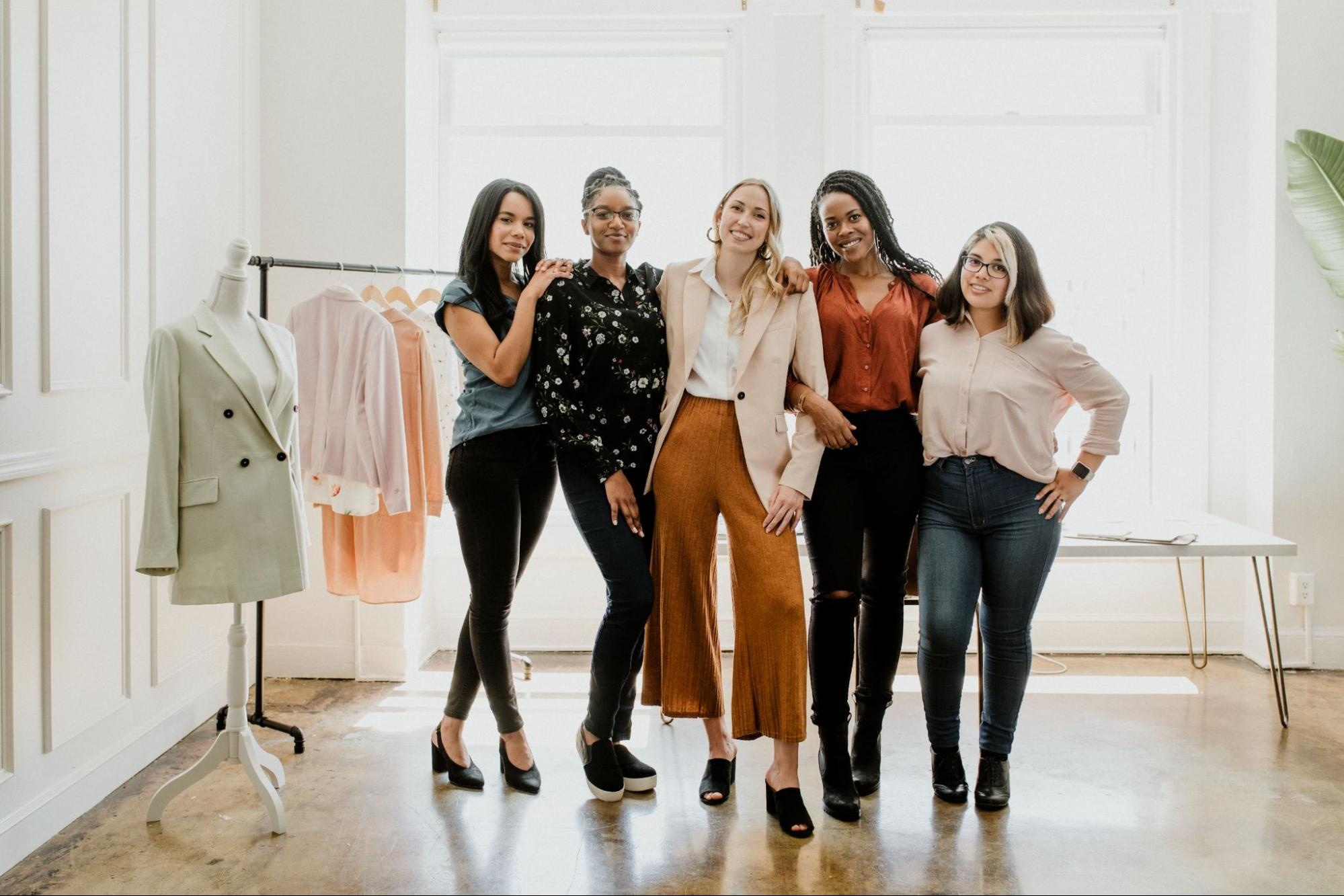 Young women designers dressed in diverse outfits in a boutique.