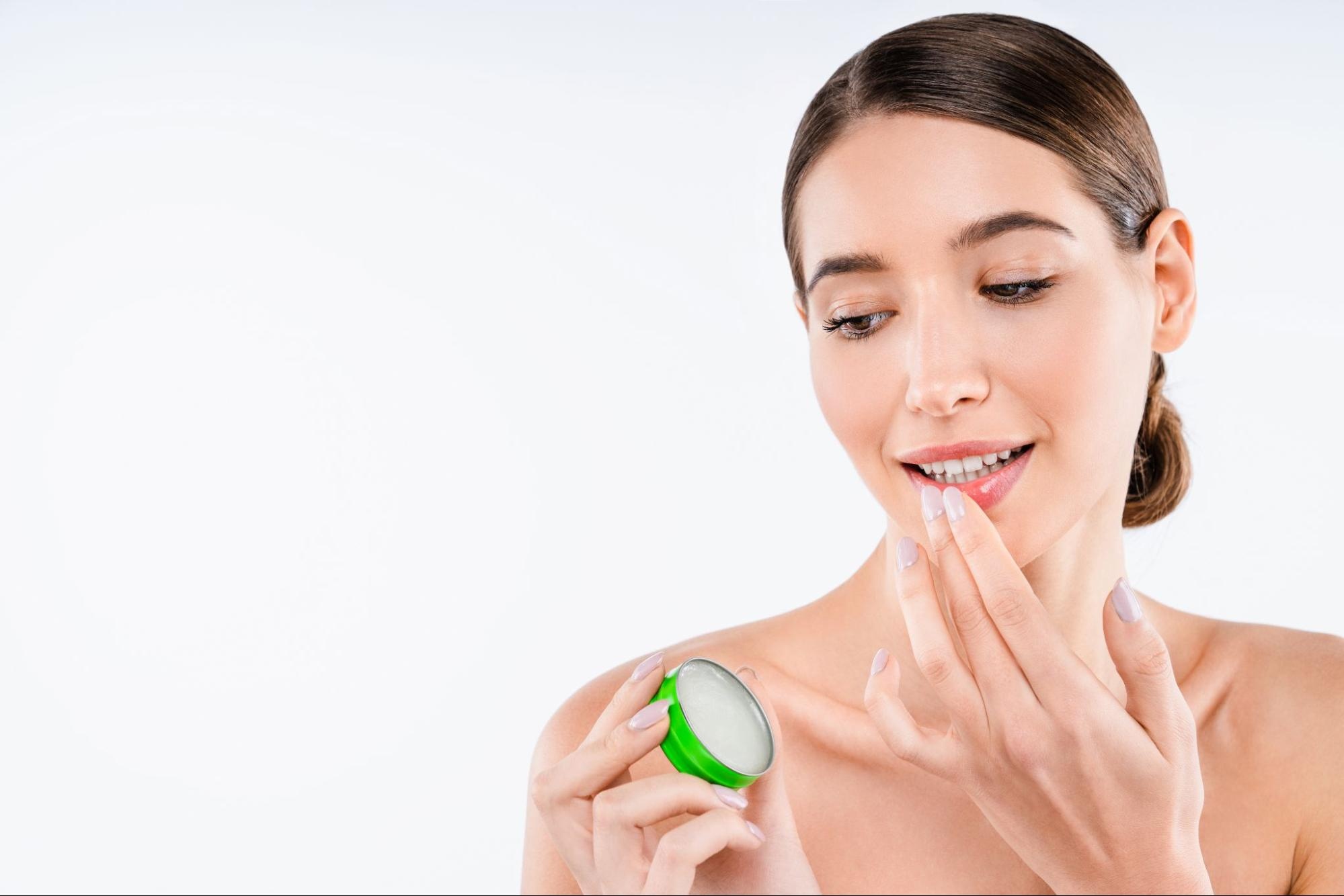 Woman uses lip products on her bottom lip.