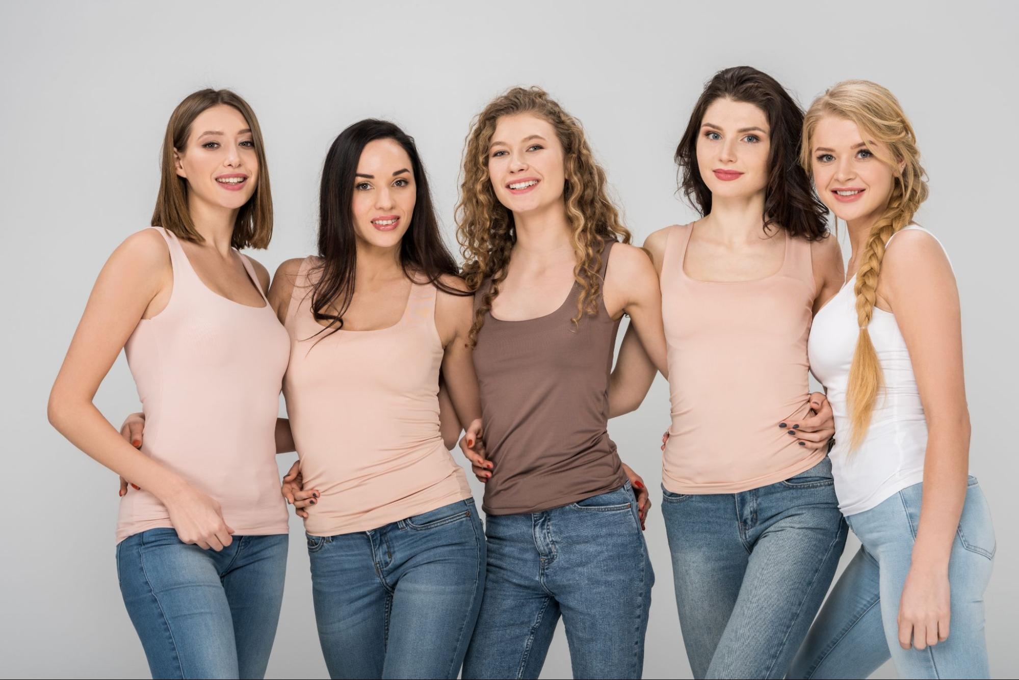 Five women pose for a photo wearing muscle tanks.