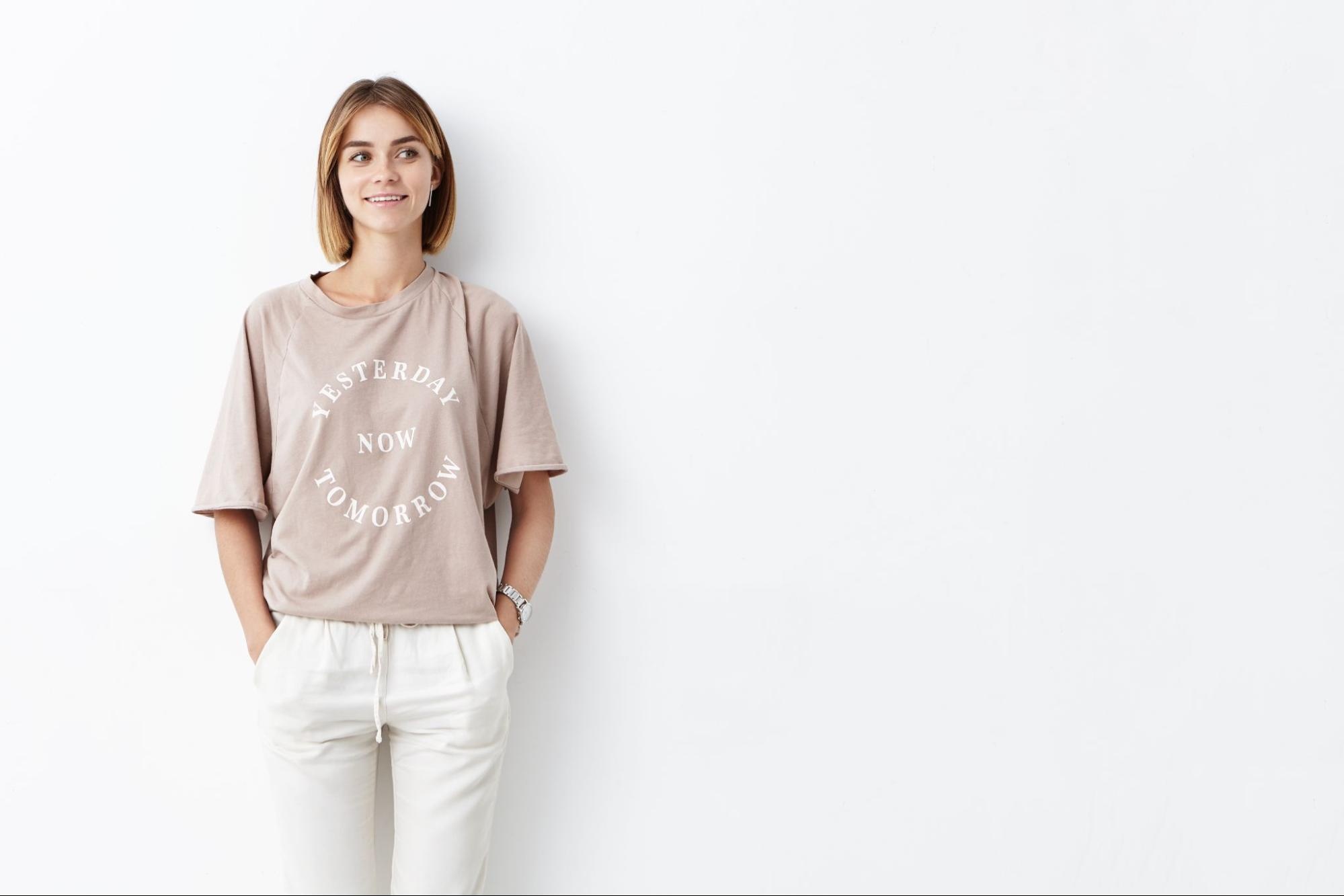 Woman smiling and wearing a graphic t-shirt with the phrase “yesterday now tomorrow.” 