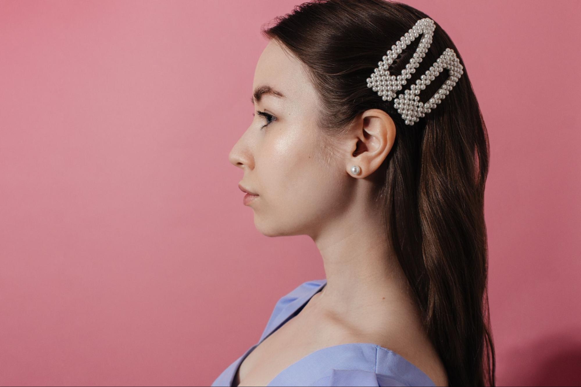 Woman wearing hair clips with peals on them. 
