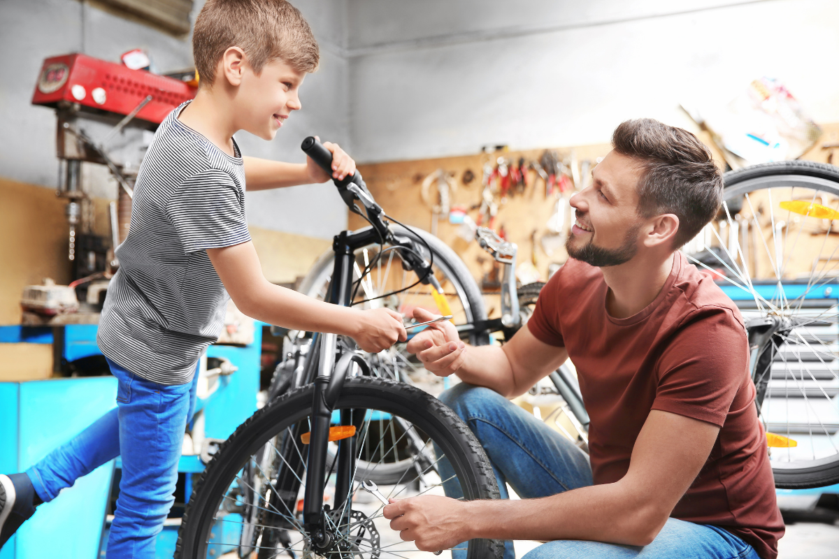 Man helping child to fix a bike
