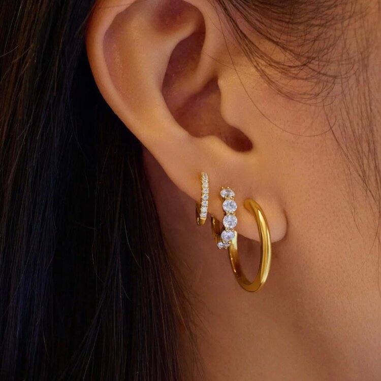 Gold Quintet Sparkle Huggie Hoop Earrings Material: 925 Sterling Silver with 14kt Gold Plating with Cubic Zirconia • Hoop Diameter: 8.5mm • Hoop Width: 1.5mm • Weight: 1.9g