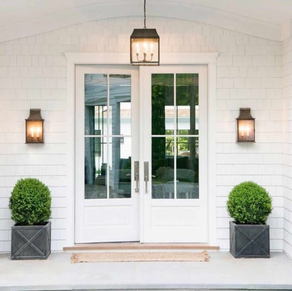 White House with shake siding and sconce lanterns. 