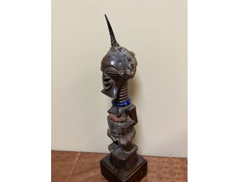 Songye or Basonge wooden figure: This fine figure had the job of protection. It's wooden with horn , blue beads or cotton fabric. The sculpture is 17 5/8" h including the base. The Songye are found in