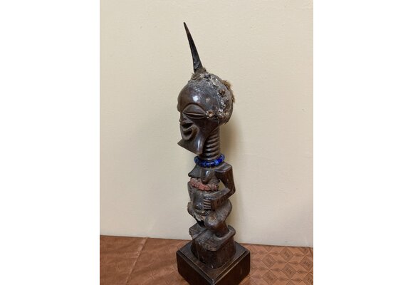 Songye or Basonge wooden figure: This fine figure had the job of protection. It's wooden with horn , blue beads or cotton fabric. The sculpture is 17 5/8" h including the base. The Songye are found in