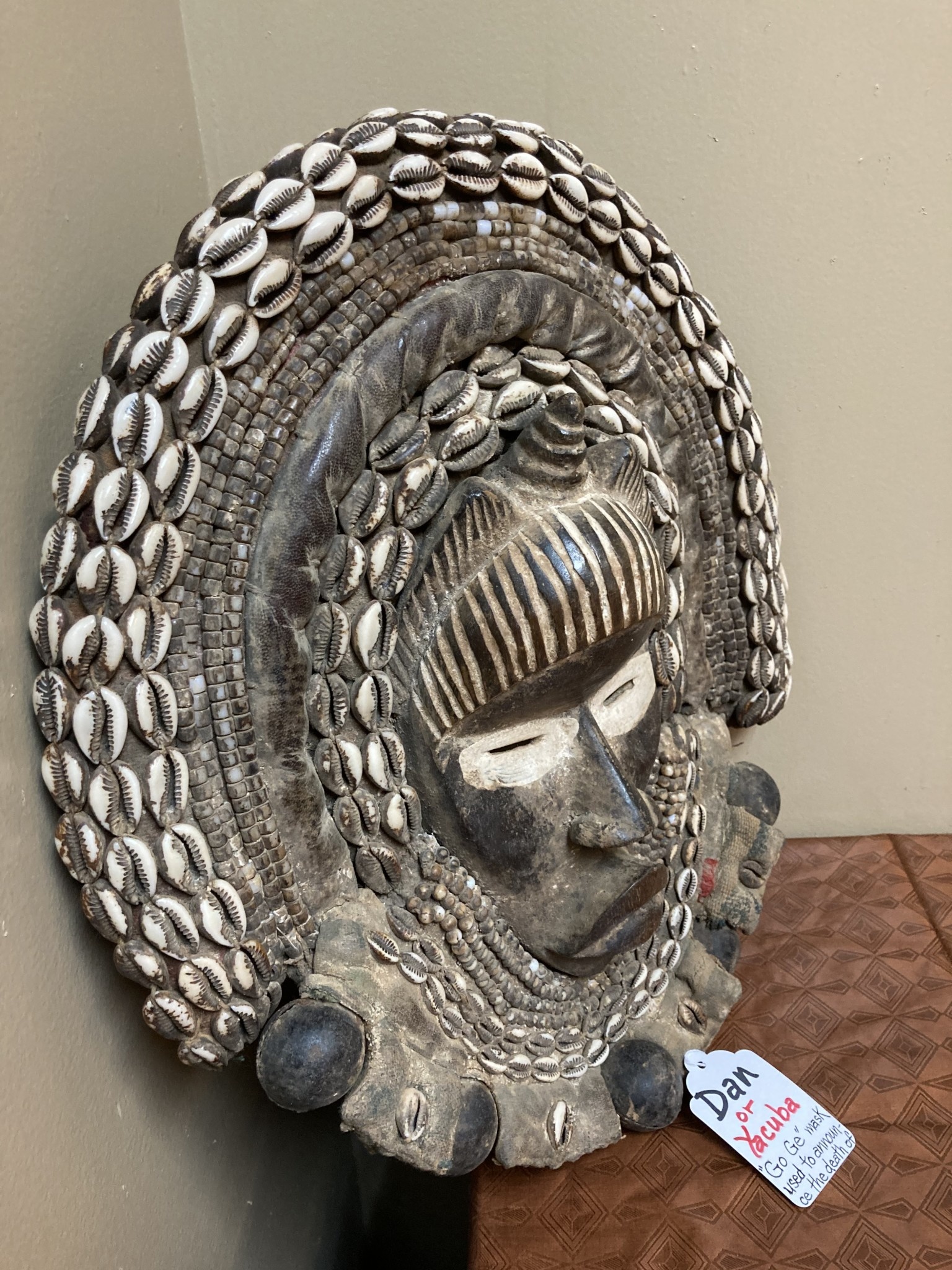 Dan (Yacuba) "Go Ge" mask: The job of this mask is to announce the death of the chief. The dan are found in SW ivory coast and next door in Liberia. Wood, cowrie shells, fabric, and kaolin (white colo