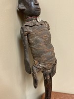 Makonde Makonde figure with handle. The Makonde live in East Africa in Mozambique, Tanzania with a small group in Kenya. This figure is used by entertainers and storytellers. Wood with cotton fabric and a cow