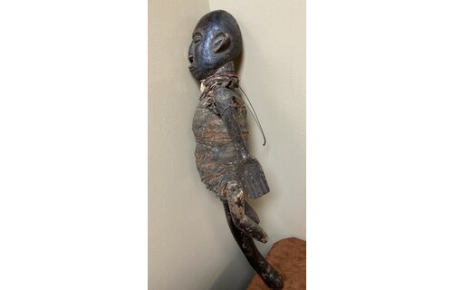 Makonde figure with handle. The Makonde live in East Africa in Mozambique, Tanzania with a small group in Kenya. This figure is used by entertainers and storytellers. Wood with cotton fabric and a cow