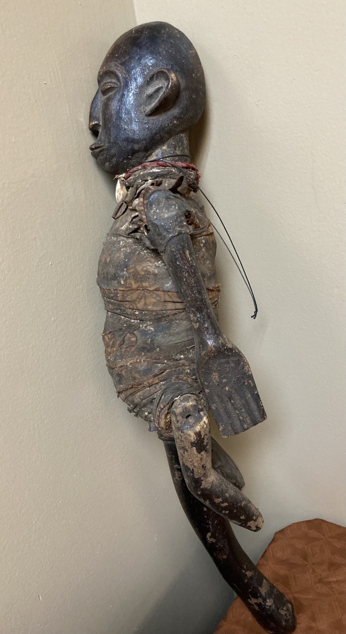 Makonde figure with handle. The Makonde live in East Africa in Mozambique, Tanzania with a small group in Kenya. This figure is used by entertainers and storytellers. Wood with cotton fabric and a cow