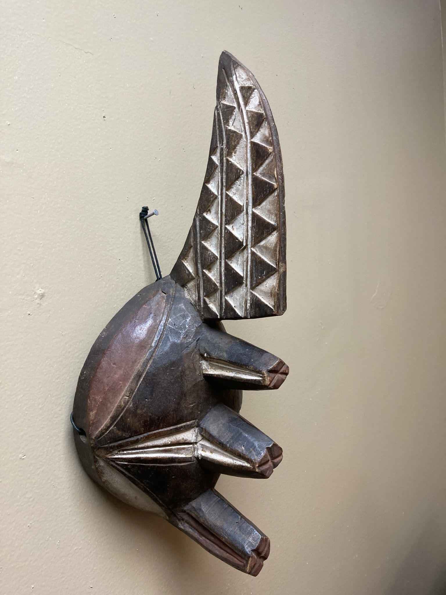 Ogoni Yam Festival Mask: At yam harvest time the Ogoni celebrate with a festival at which this mask with it’s 3 yams and crest representing the machete that cuts the vines. IT’s 17” tall and made of w