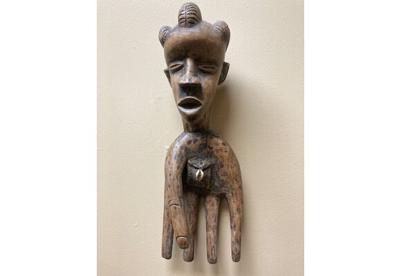 Bassa hand to serve as a power figure: The pouch in the hand’s palm contains magical substances. The piece is wooden and measures 17” long and 5 ⅞” wide. The Bassa reside in Liberia.