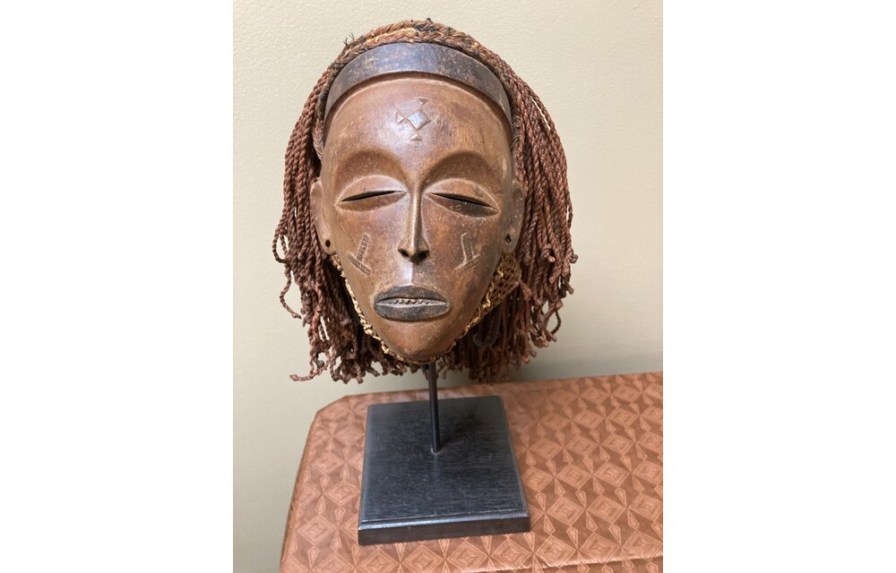 “Mwana Pwo” mask of the Chokwe (Tchokwe or Bajokwer) of Angola. Pwo is their word for woman. It represents a young woman who has been fully trained and is ready for marriage. Stand is included. Total