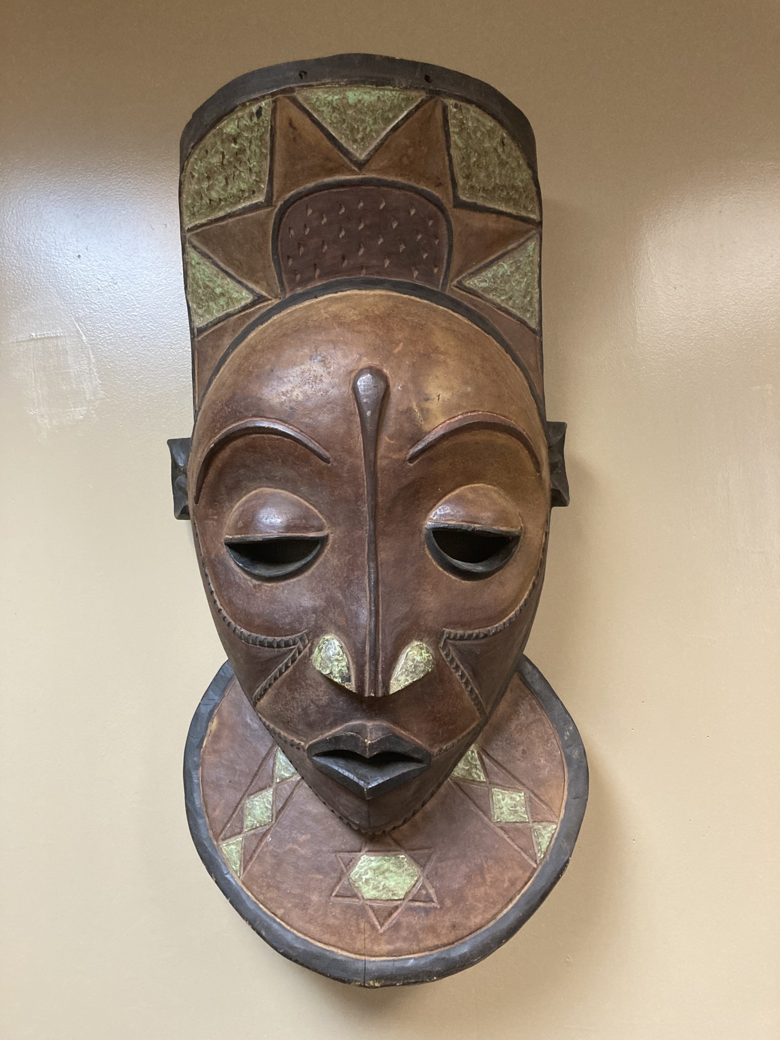 Pende X-Large Mask: The Bapende are found in Dem Rep of Congo. This mask is 35 ½” tall and 16 ½” wide. Masks this size often decorated a meeting house. Wooden