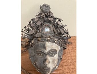 Kongo (Bakongo) wooden power figure or “Nkisi” Mask. It is decorated with cowrie shells, twine, iron nails, glass, and seeds. The Kongo ethnic group is found in Dem Rep of Congo. 16 ½ “ x 11 “