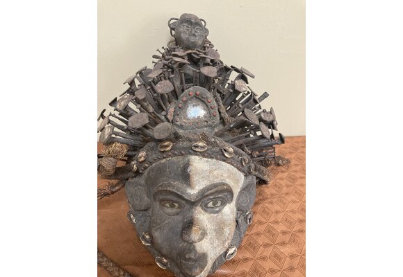 Kongo (Bakongo) wooden power figure or “Nkisi” Mask. It is decorated with cowrie shells, twine, iron nails, glass, and seeds. The Kongo ethnic group is found in Dem Rep of Congo. 16 ½ “ x 11 “