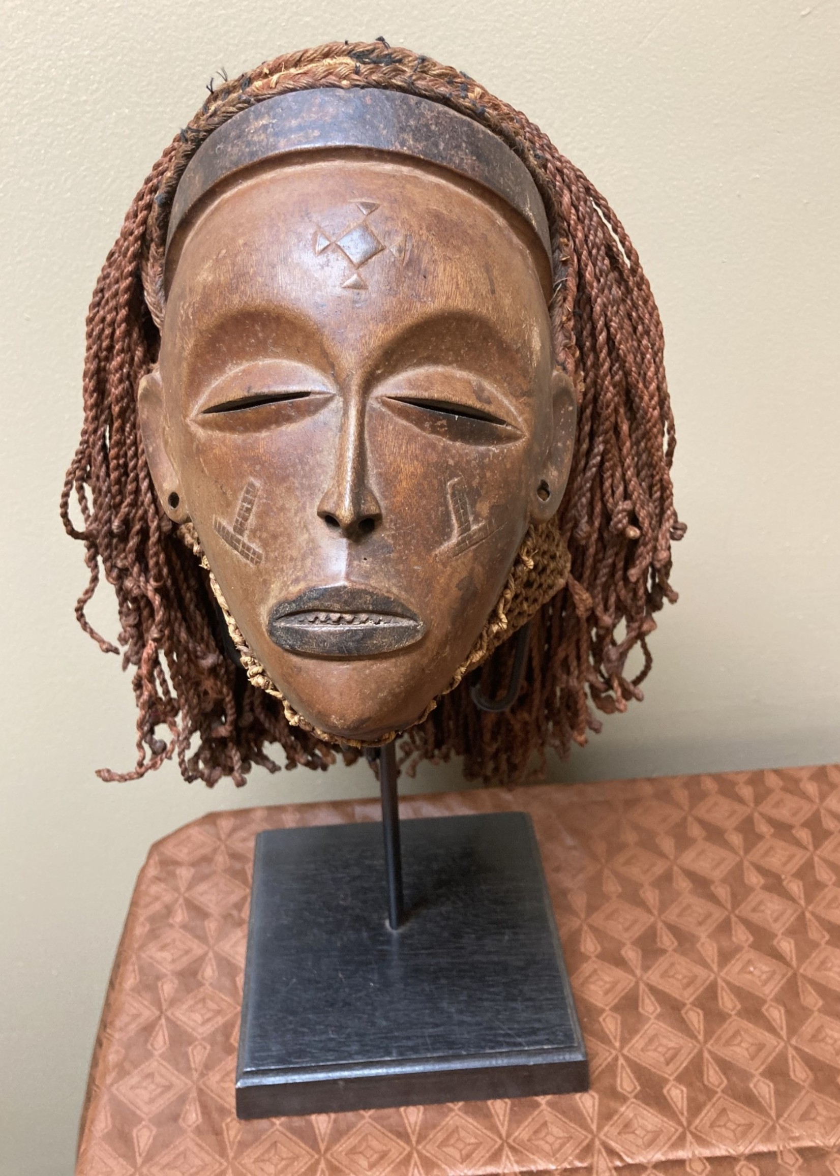Chokwe “Mwana Pwo” mask of the Chokwe (Tchokwe or Bajokwer) of Angola. Pwo is their word for woman. It represents a young woman who has been fully trained and is ready for marriage. Stand is included. Total height is 17 ⅛”