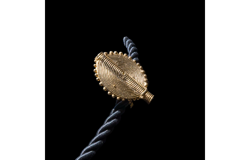 Corded necklace with large brass pendant and clip-on earrings.