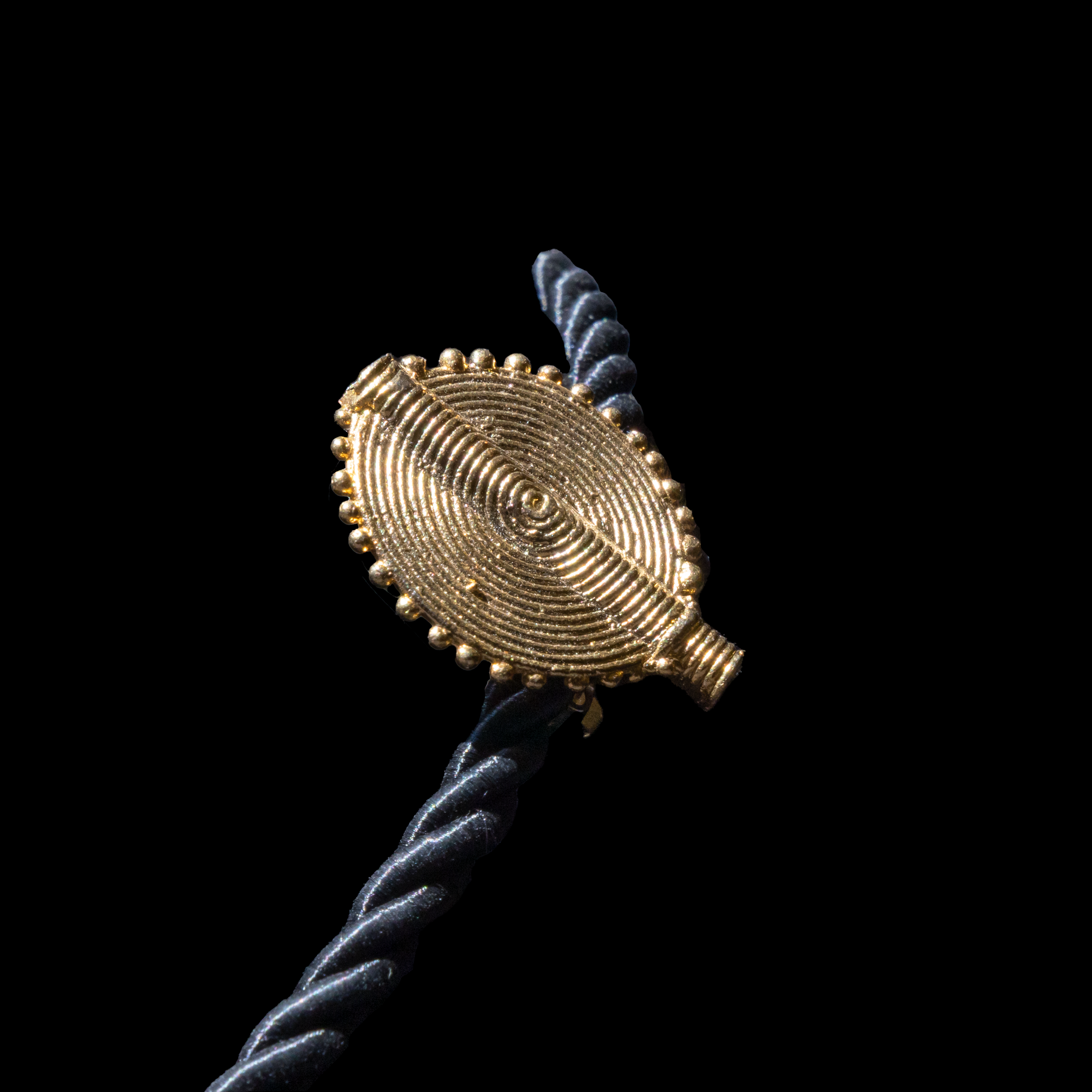 Corded necklace with large brass pendant and clip-on earrings.