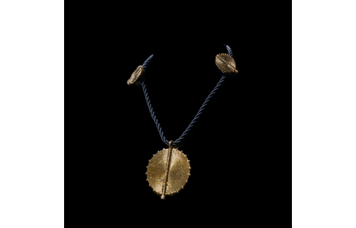 Corded necklace with large brass pendant and clip-on earrings.