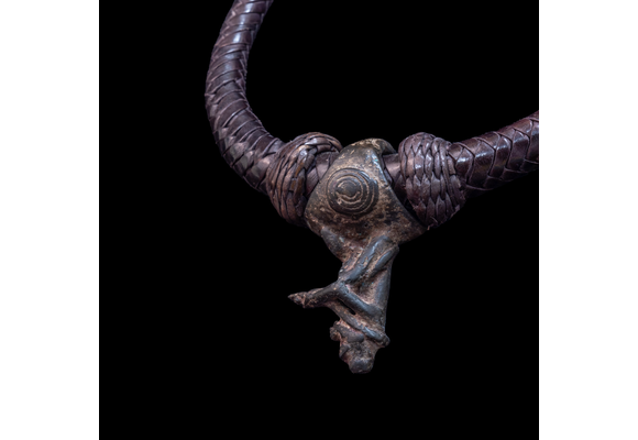 Braided leather necklace with small antique bronze pendant.