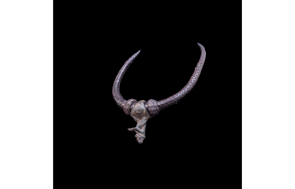 Braided leather necklace with small antique bronze pendant.