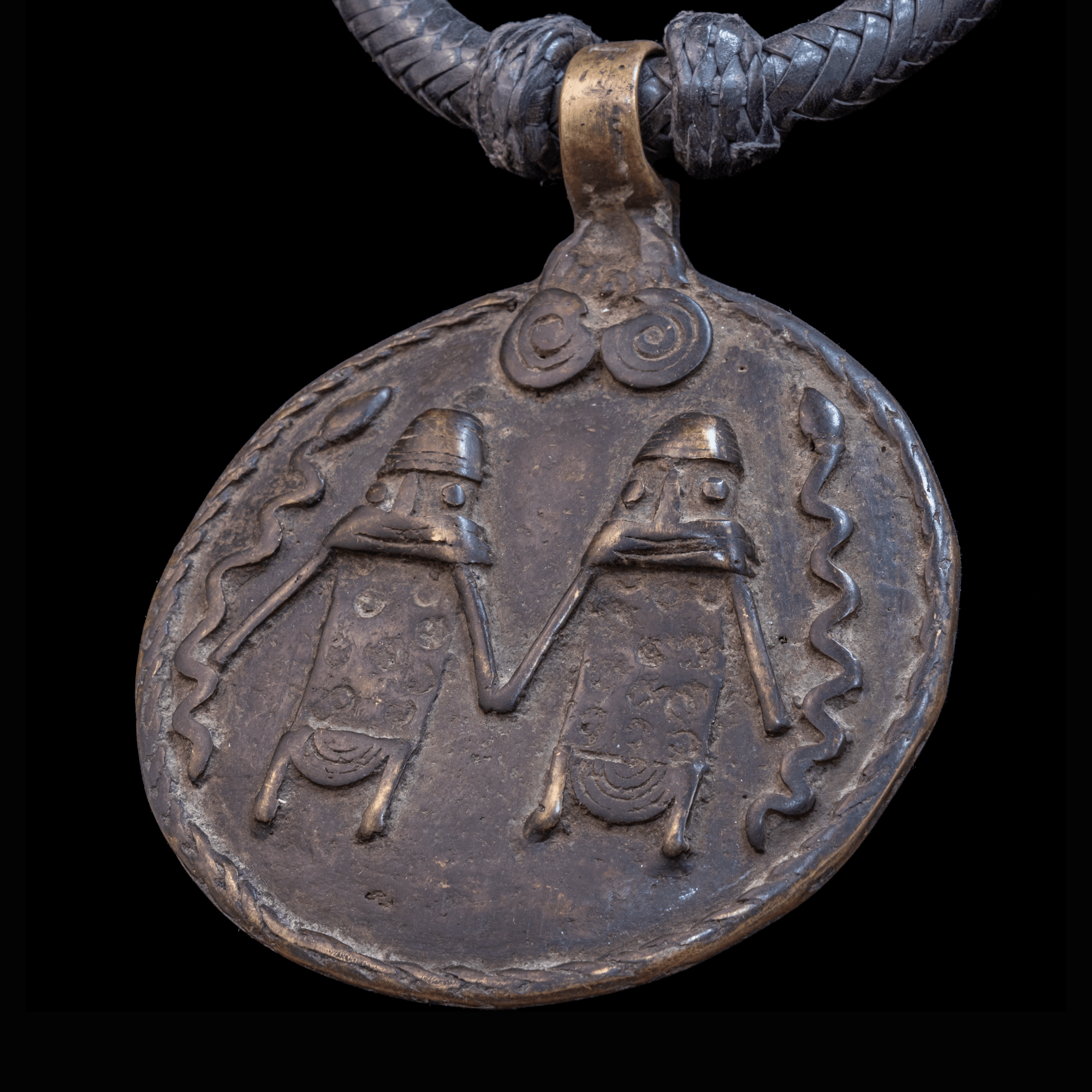 Braided leather necklace with antique bronze pendant.
