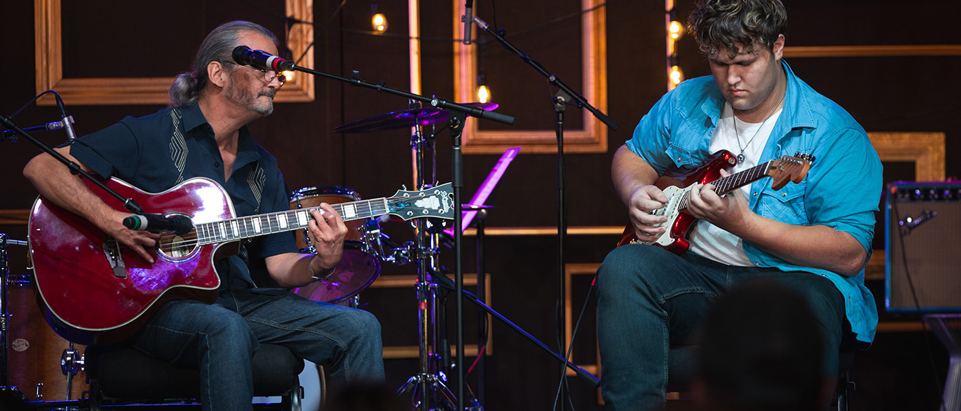 student taking guitar lessons with teacher