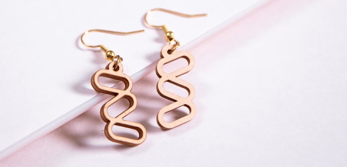 Earrings with a DNA strand design cut by a FLUX Beamo.