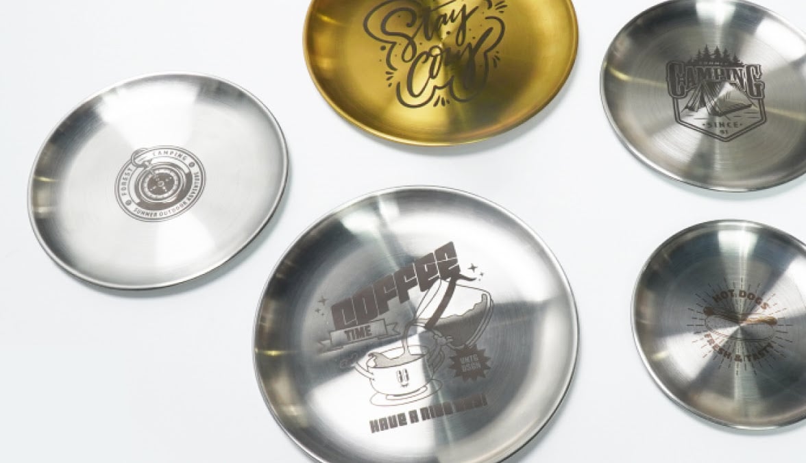 Assortment of metal plates and dishes with different engravings by the FLUX Ador.